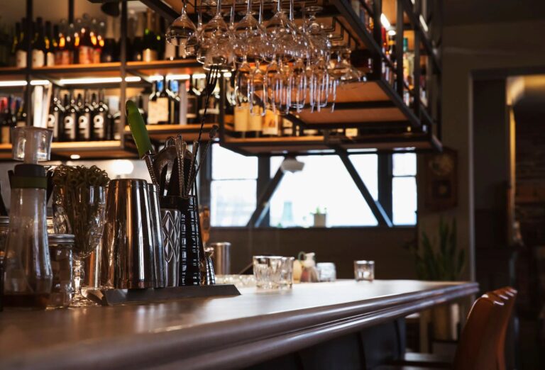 The bar, with glassware hanging above the counter and bottles on the back shelves