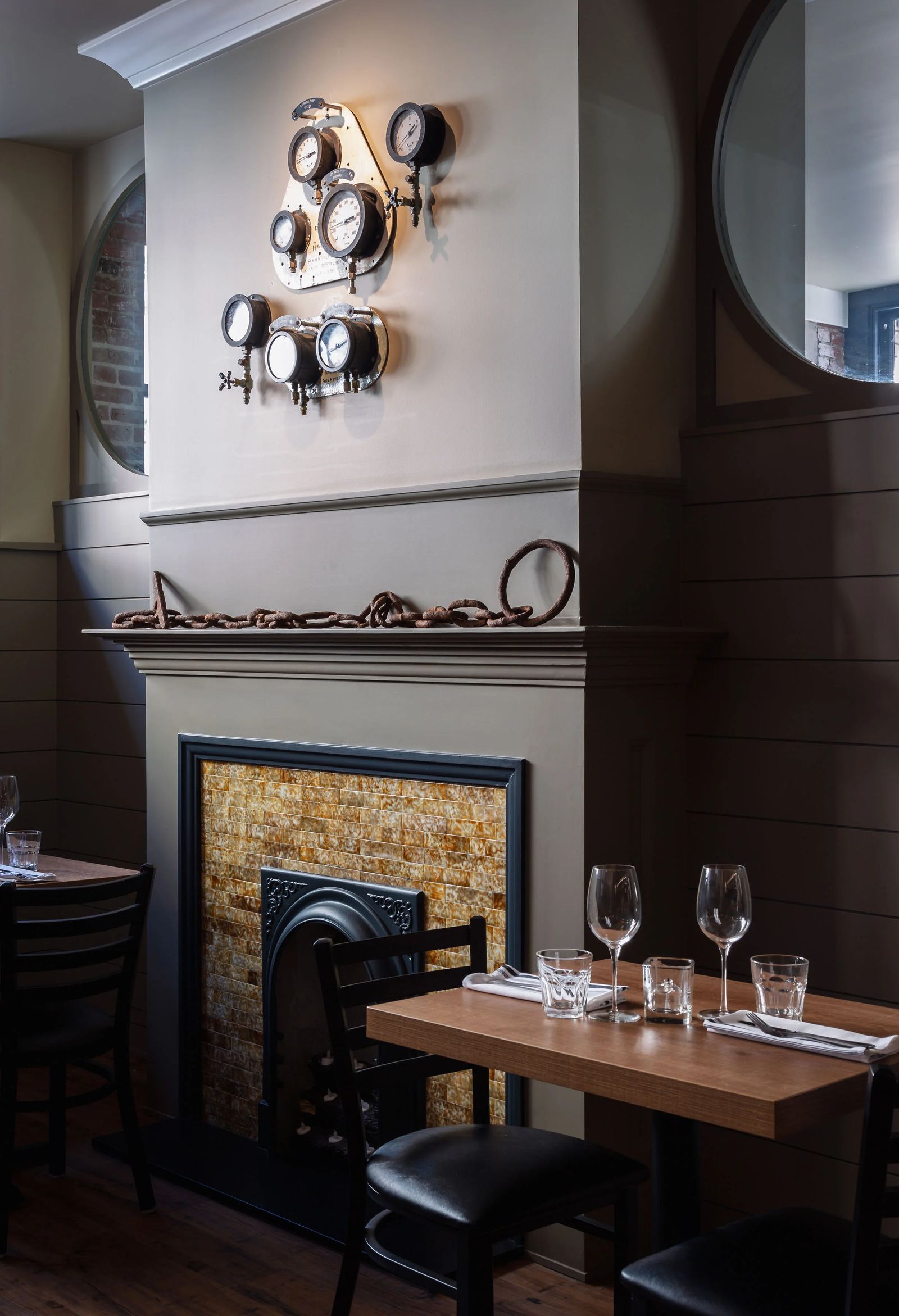 A table set for two beside the dining room fireplace, wine glasses ready