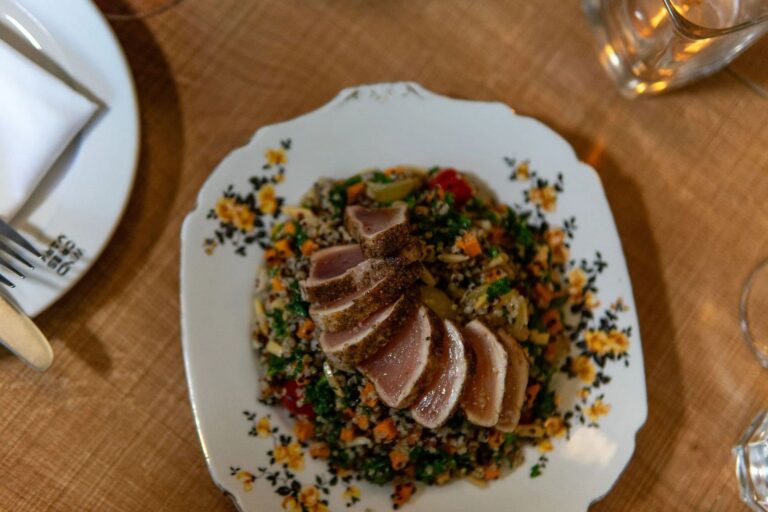 A plated main course photographed from above, sliced and fanned across the plate